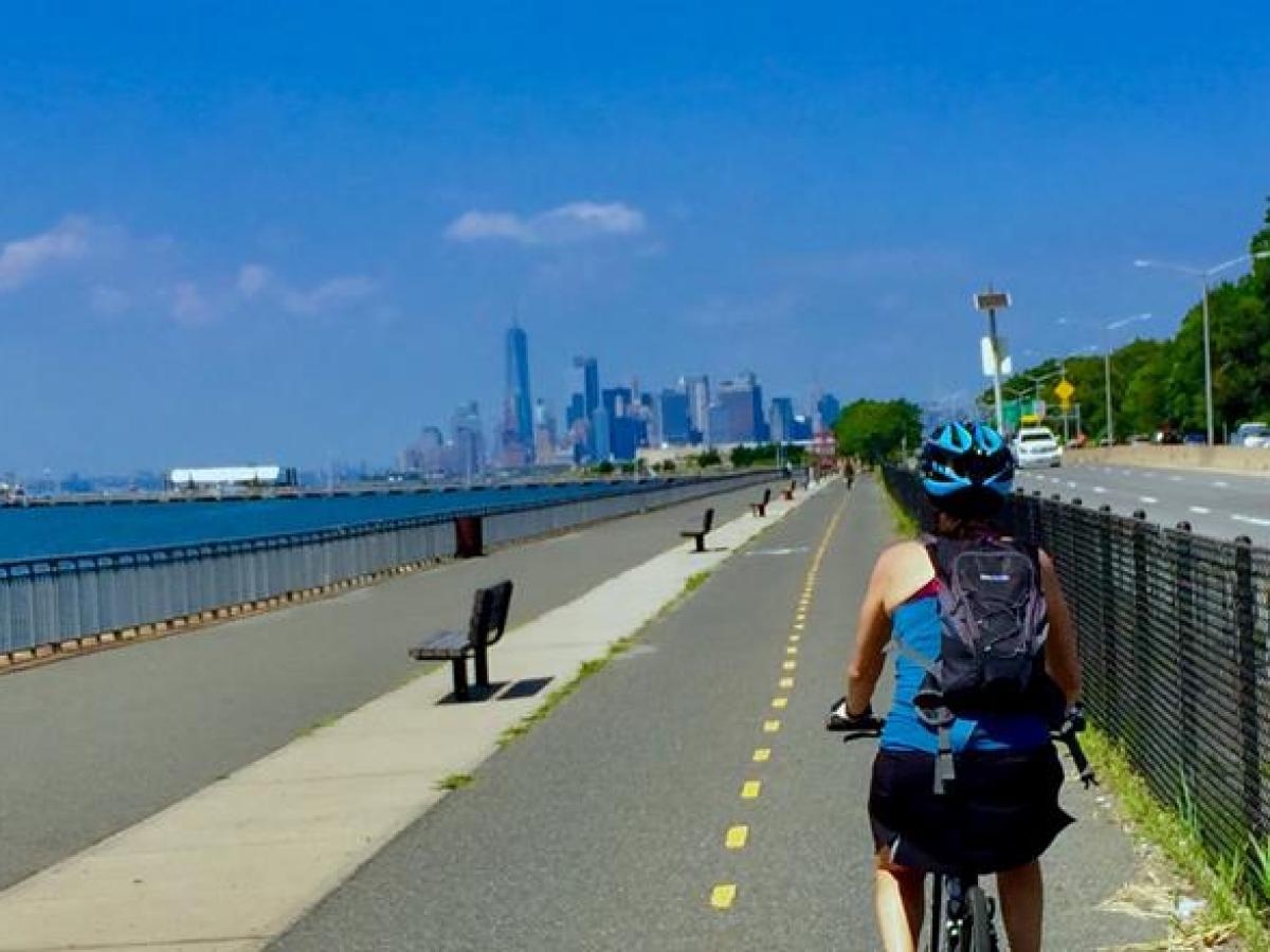 ebike on greenway by ocean with nyc skyline