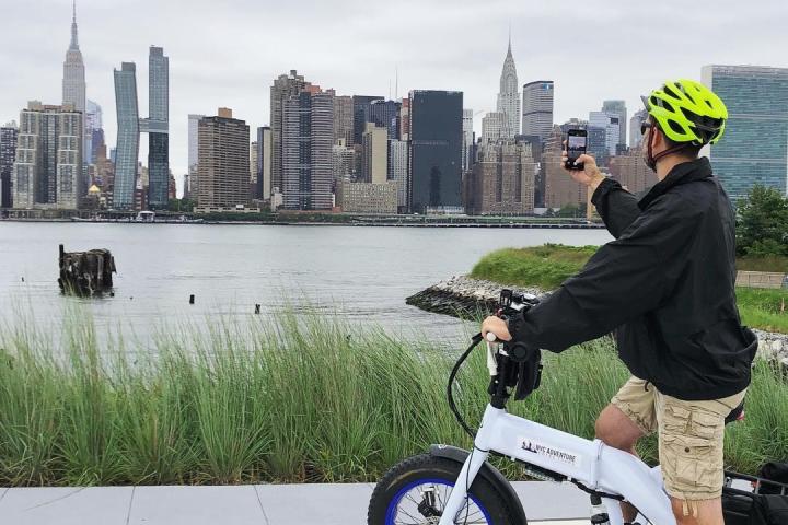 customer on ebike taking picture of nyc skyline