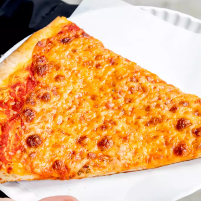 Slice of cheese pizza on a paper plate.