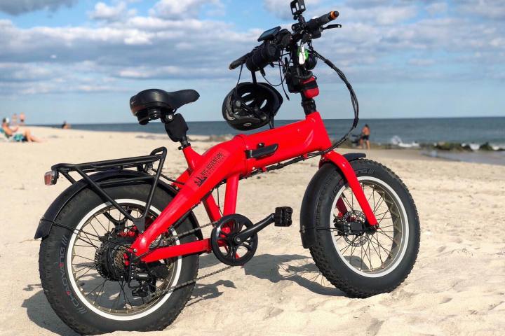 a red motorcycle parked next to a body of water